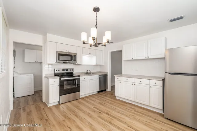 a kitchen with white cabinets stainless steel appliances and sink