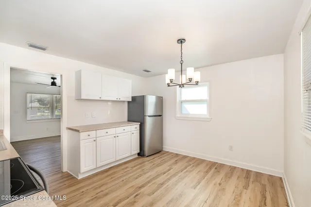 a kitchen with a sink stainless steel appliances cabinets and a wooden floor