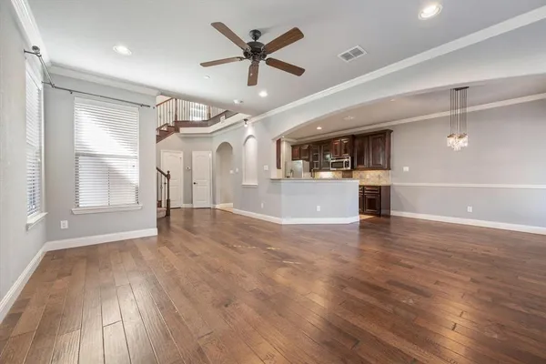 a view of empty room with wooden floor and window
