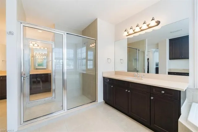 a spacious bathroom with a shower sink and mirror
