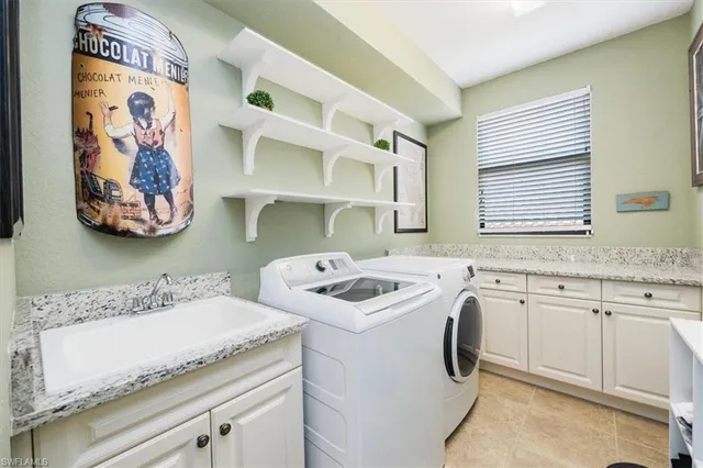 a utility room with stainless steel appliances granite countertop a sink and a stove