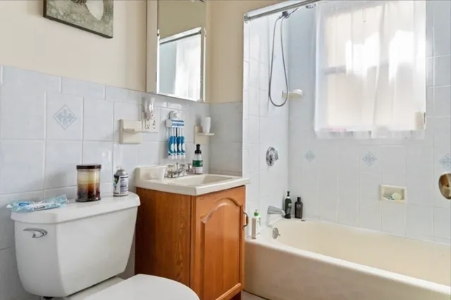 a bathroom with a sink toilet vanity and bathtub