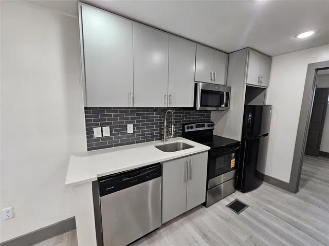 a kitchen with a sink stove and refrigerator