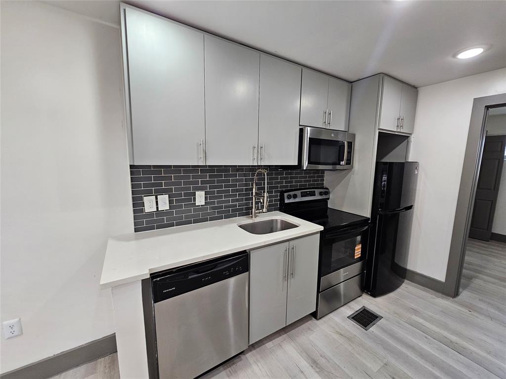 4806 Virginia Avenue, Unit 108 Dallas, TX 75204 - Photo 5 of 9 a kitchen with a sink stove and refrigerator