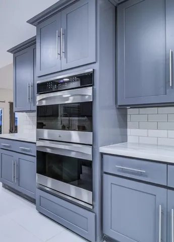 a kitchen with granite countertop white cabinets and stainless steel appliances