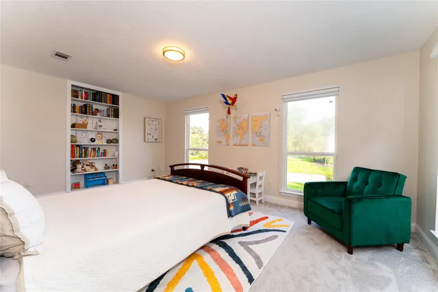 a bedroom with furniture and a large window