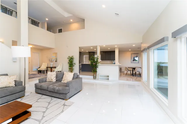 a living room with furniture kitchen view and a large window