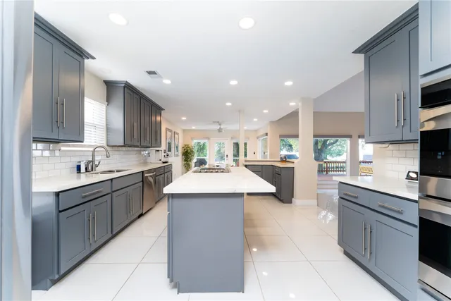 a kitchen with stainless steel appliances kitchen island granite countertop a sink and cabinets