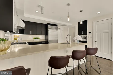 a kitchen with stainless steel appliances kitchen island granite countertop a stove a sink a dining table and chairs
