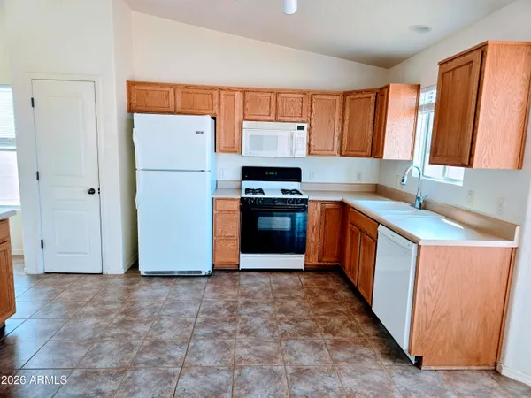 a kitchen with stainless steel appliances granite countertop a refrigerator a sink and a stove