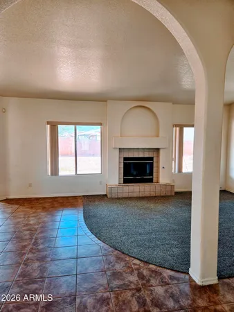 a view of empty room with wooden floor and fireplace