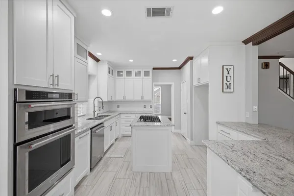 a kitchen with stainless steel appliances granite countertop a stove and cabinets