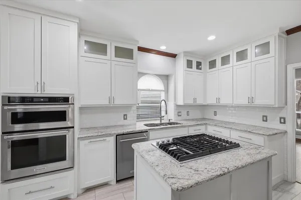 a kitchen with white cabinets and appliances