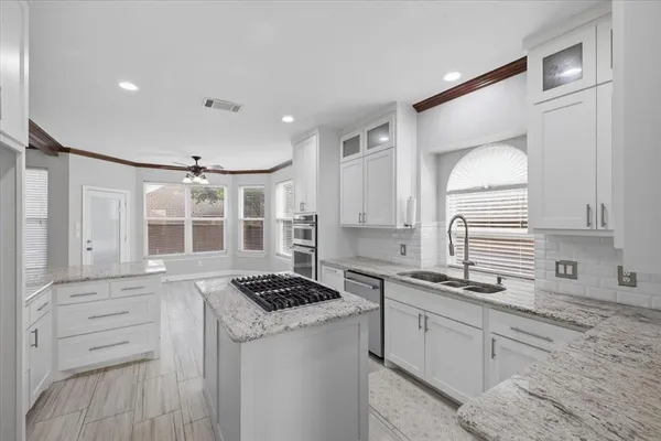 a kitchen with granite countertop white cabinets and white appliances