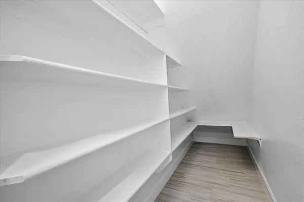 a view of a hallway with wooden floor and entryway