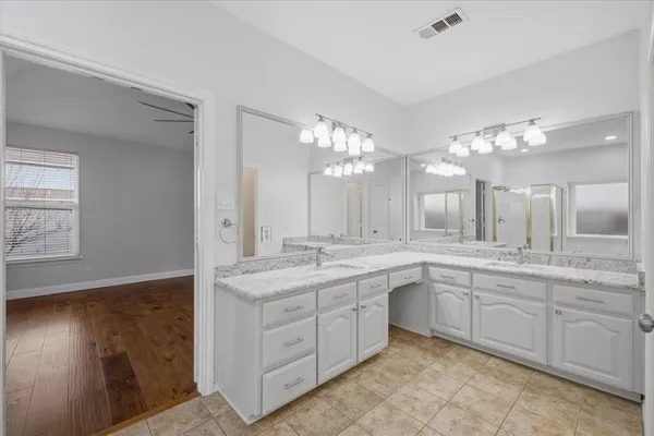 a large white kitchen with a sink and dishwasher with a large kitchen island