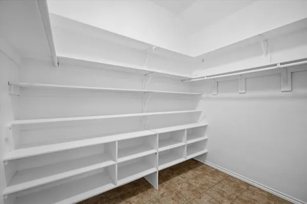 a view of walk in closet with empty racks