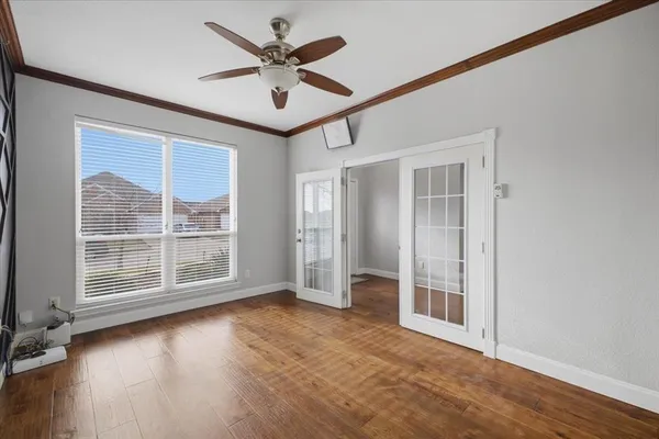 an empty room with wooden floor and windows