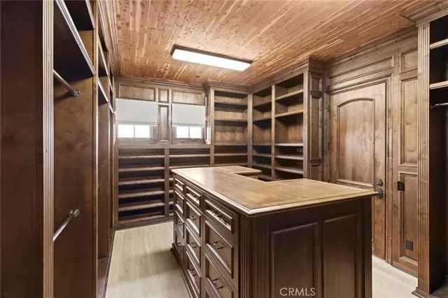 a view of a patio with couches fire pit and a barbeque grill with plants and large trees