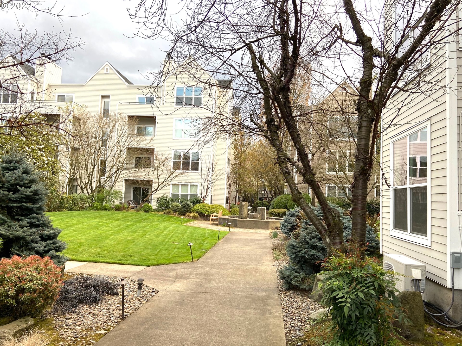 1730 South Harbor Way, Unit 405 Portland, OR 97201 - Photo 32 of 32 a view of a white house next to a yard with big trees