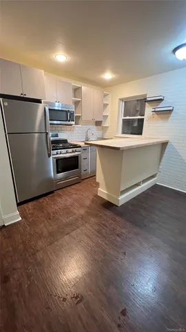 a kitchen with stainless steel appliances a refrigerator and a stove top oven
