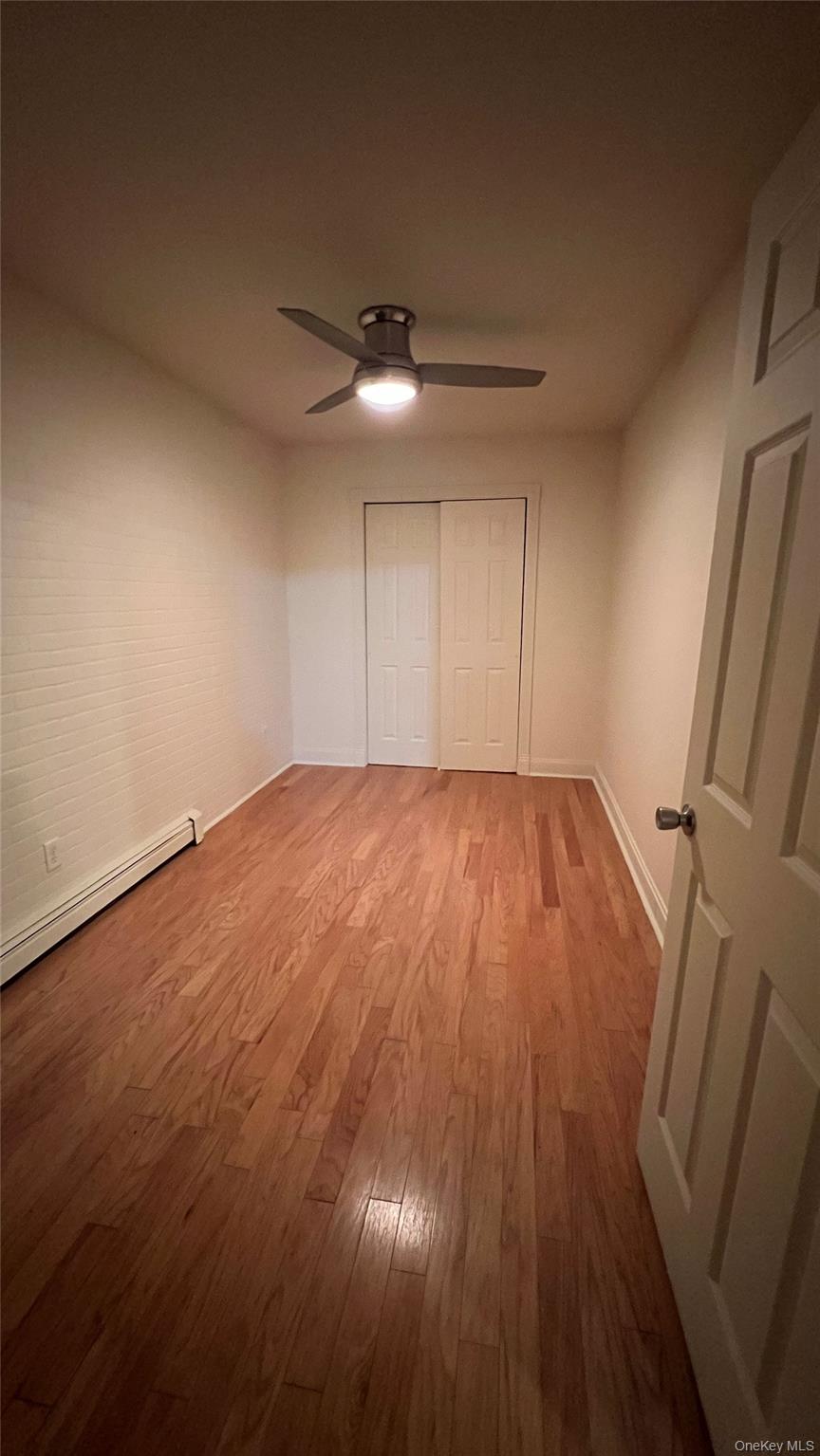 27 East Main Street, Unit 3 Beacon, NY 12508 - Photo 6 of 8 an empty room with wooden floor fan and windows
