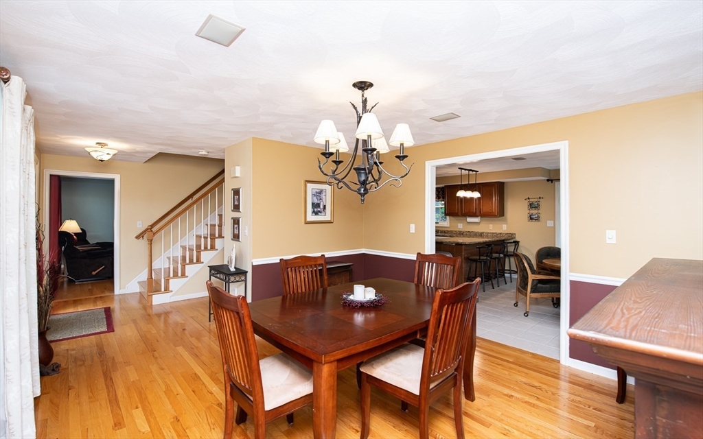 6 Innisfree Drive Haverhill, MA 01832 - Photo 13 of 41 a dining room with wooden floor a chandelier a wooden table and chairs