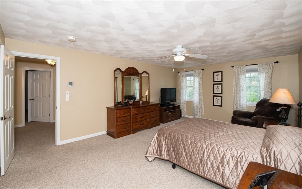 6 Innisfree Drive Haverhill, MA 01832 - Photo 21 of 41 a bedroom with a bed a dresser and a chandelier