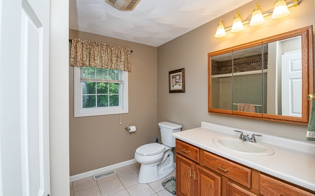 6 Innisfree Drive Haverhill, MA 01832 - Photo 22 of 41 a bathroom with a granite countertop toilet a sink a mirror and a window