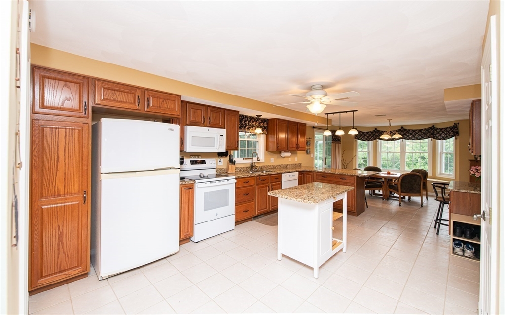 6 Innisfree Drive Haverhill, MA 01832 - Photo 4 of 41 a kitchen with a refrigerator and white cabinets