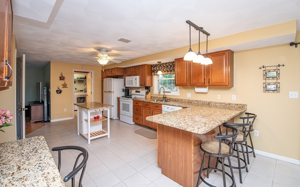 6 Innisfree Drive Haverhill, MA 01832 - Photo 5 of 41 a kitchen with stainless steel appliances granite countertop table chairs and a refrigerator