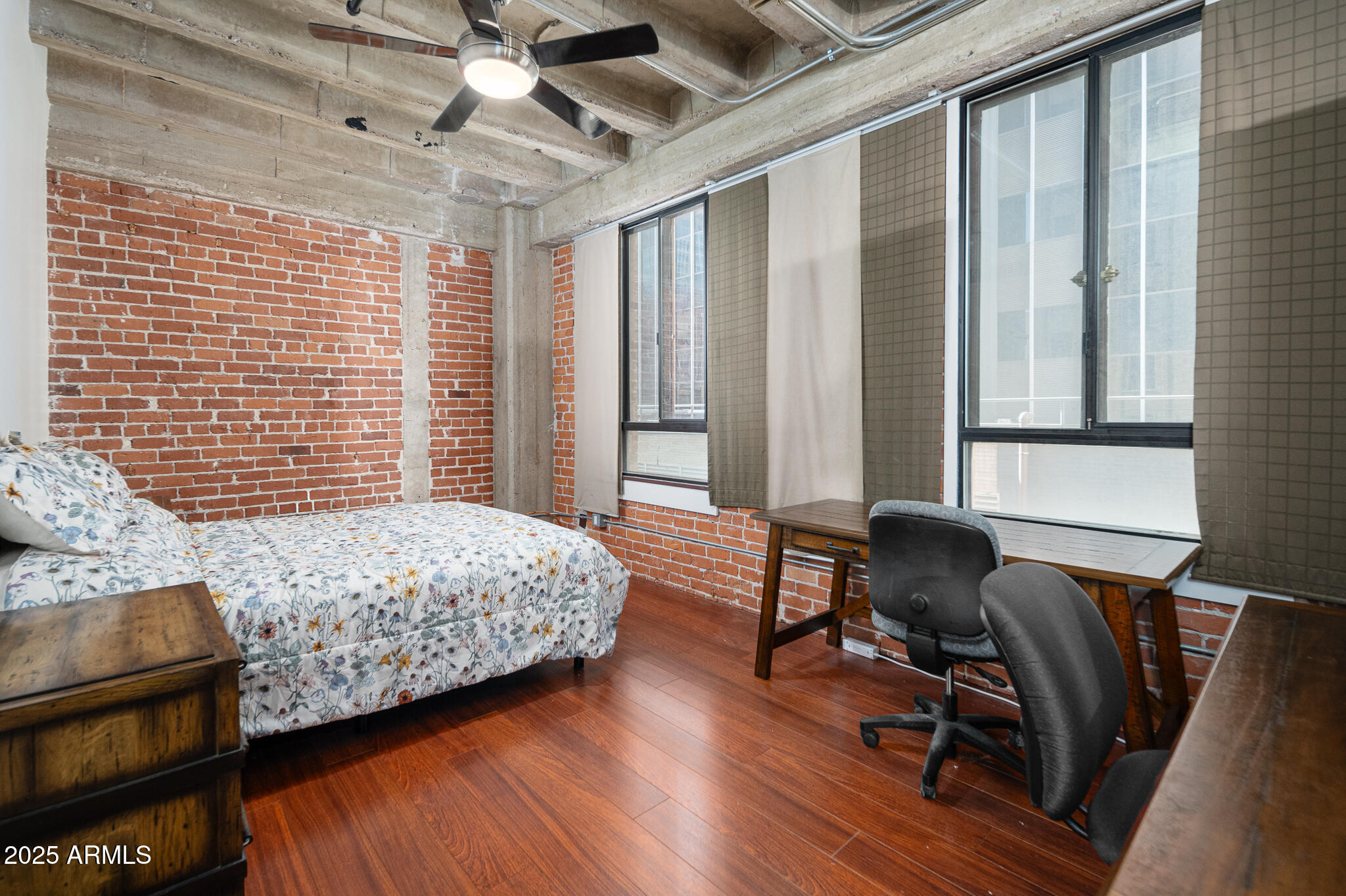 114 West Adams Street, Unit 402 Phoenix, AZ 85003 - Photo 4 of 25 a bedroom with a bed a desk and chair with wooden floor