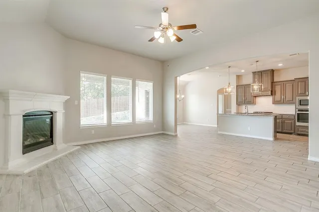 a view of a kitchen with furniture a ceiling fan and wooden floor