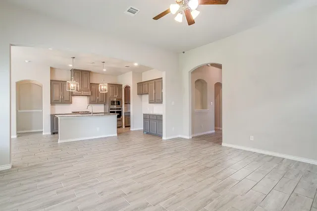 a view of kitchen with kitchen island stainless steel appliances cabinets and wooden floor