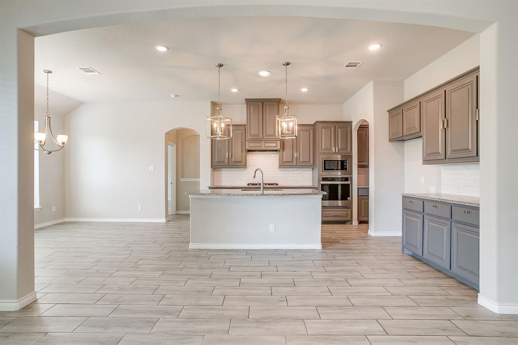 1281 Palo Duro Court Burleson, TX 76028 - Photo 15 of 39 a large kitchen with cabinets a sink a window and stainless steel appliances