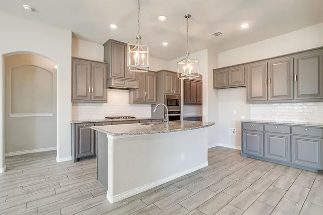 a kitchen with kitchen island white cabinets and stainless steel appliances