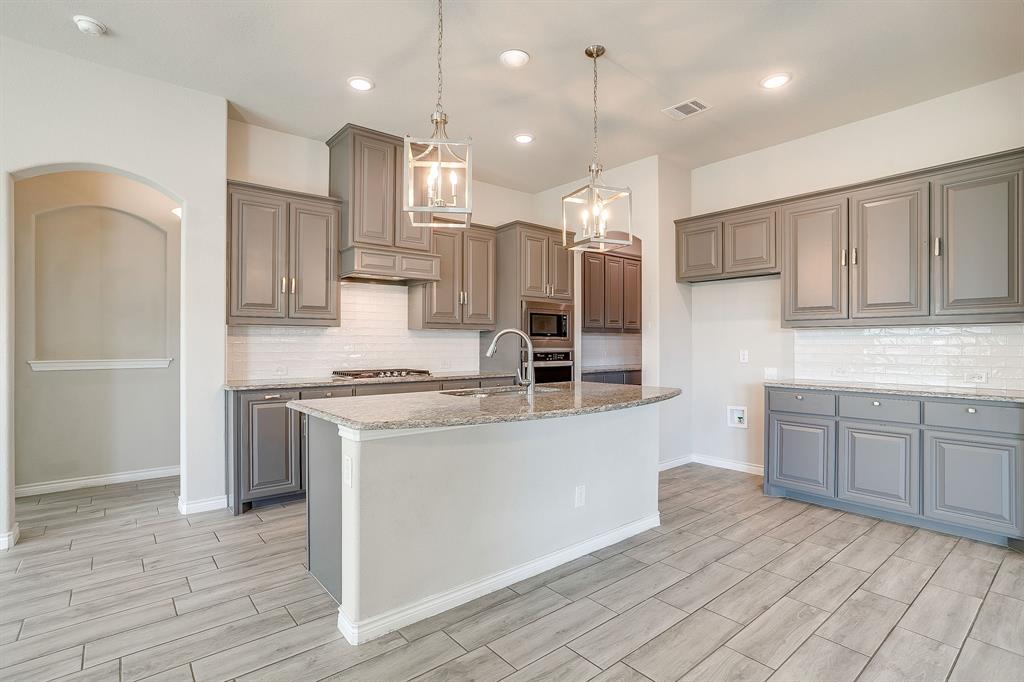 1281 Palo Duro Court Burleson, TX 76028 - Photo 16 of 39 a kitchen with kitchen island white cabinets and stainless steel appliances