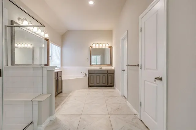 a bathroom with a bathtub sink and mirror