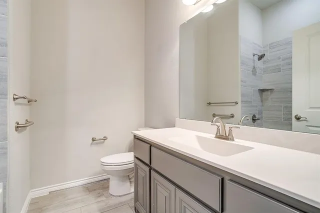 a bathroom with a sink a toilet and a large mirror