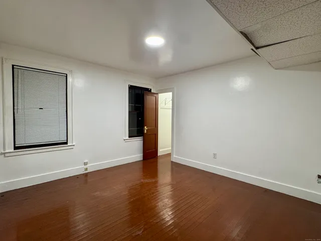 an empty room with a fireplace and wooden floor