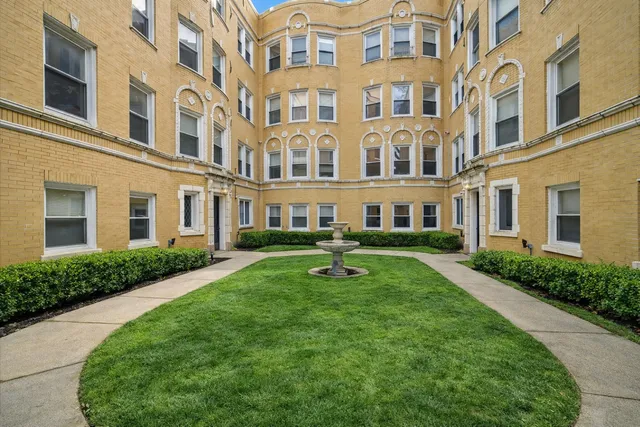 front view of a brick building with a yard