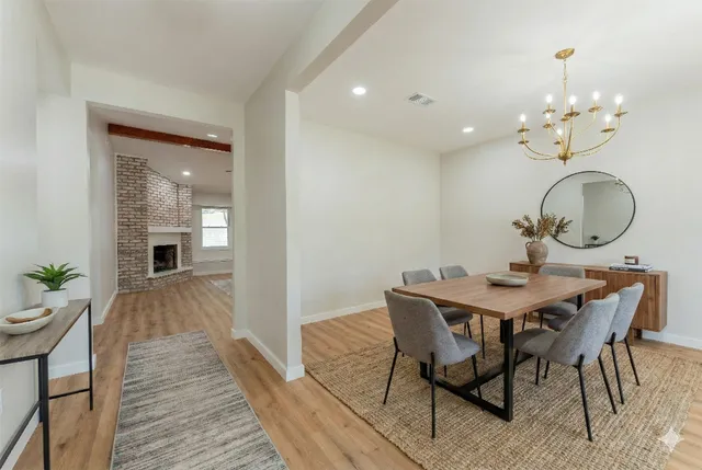 a view of a dining room with furniture a chandelier and wooden floor