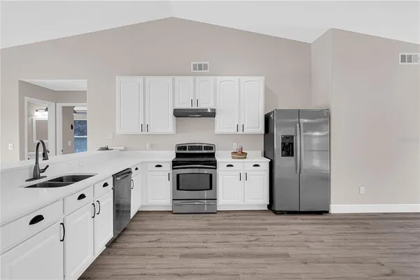 a kitchen with stainless steel appliances a refrigerator sink and cabinets