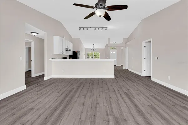 a view of a kitchen with wooden floor and a ceiling fan