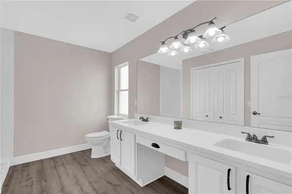 a bathroom with a sink a toilet and a mirror