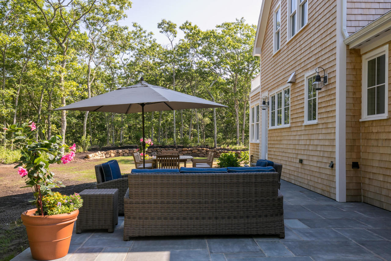 28 Fishermans Knot Road Edgartown, MA 02539 - Photo 24 of 30 a view of a patio with couches chairs potted plants and a tree