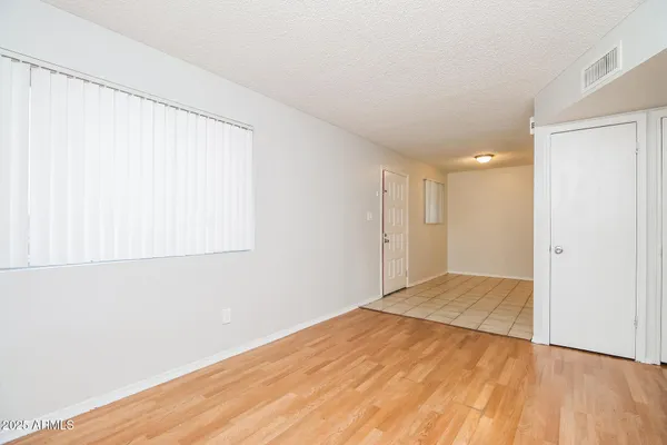a view of an empty room with wooden floor