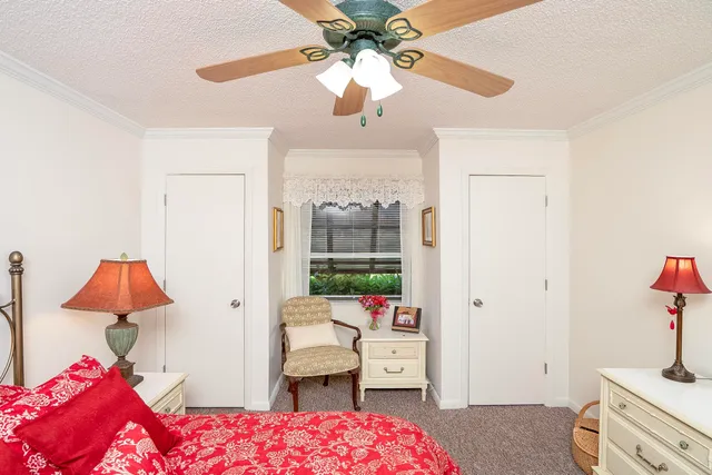 a bedroom with a bed dresser and a chandelier