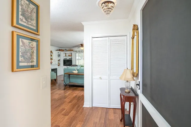 a view of a hallway to a livingroom with furniture and wooden floor