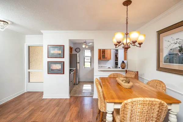 a view of a dining room with furniture a chandelier and wooden floor